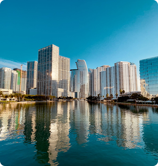 City skyline reflected in calm water.