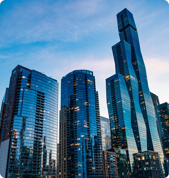 Skyscrapers reflecting sunset under clear sky.
