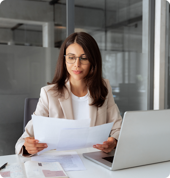 Woman reviewing documents at office desk.