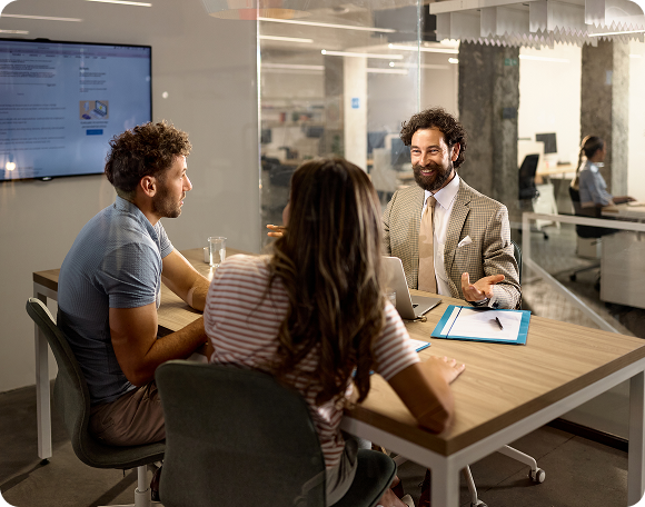 Office meeting with three people discussing.